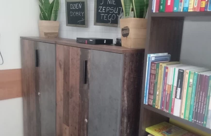 dwie komody obok szafka z książkami