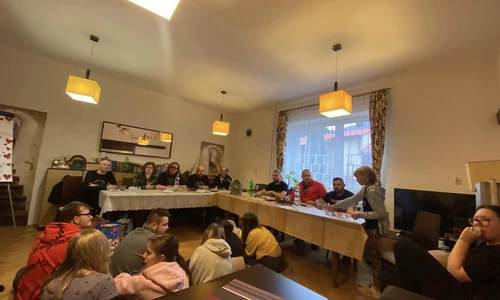 goście wraz z wychowankami siedza przy stole