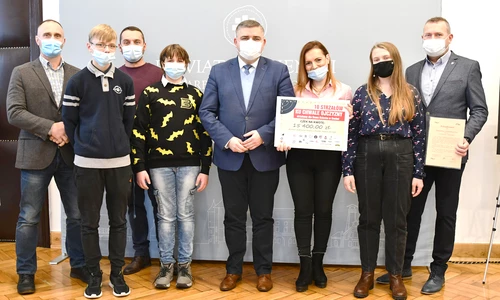 Pan Starosta, obok wychowawcy i wychowankowie odbieraja nagrodę pieniężną